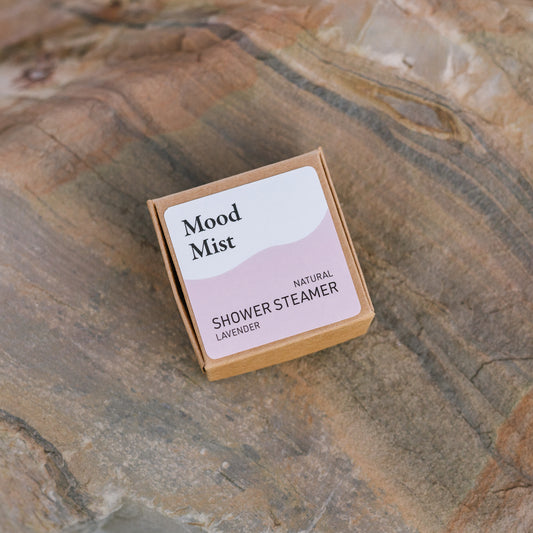 Mood Mist natural shower steamer packaging on a stone surface